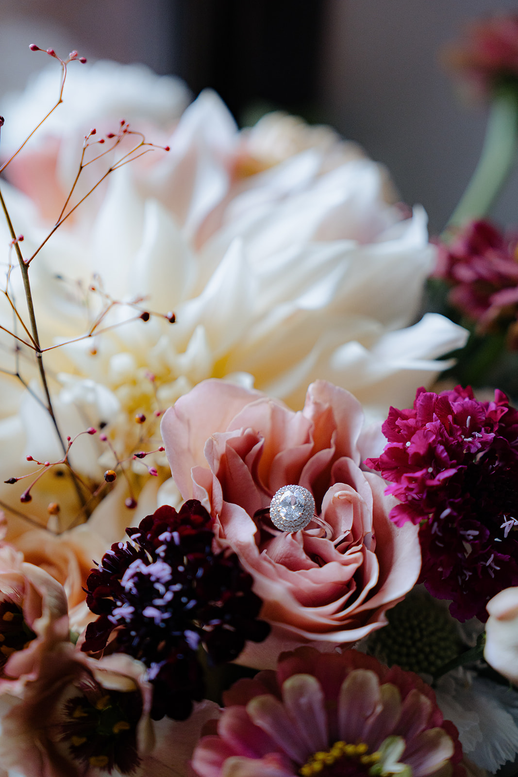 A wedding seating chart and table plan on a thin black wrought iron stand with flowers at the base.