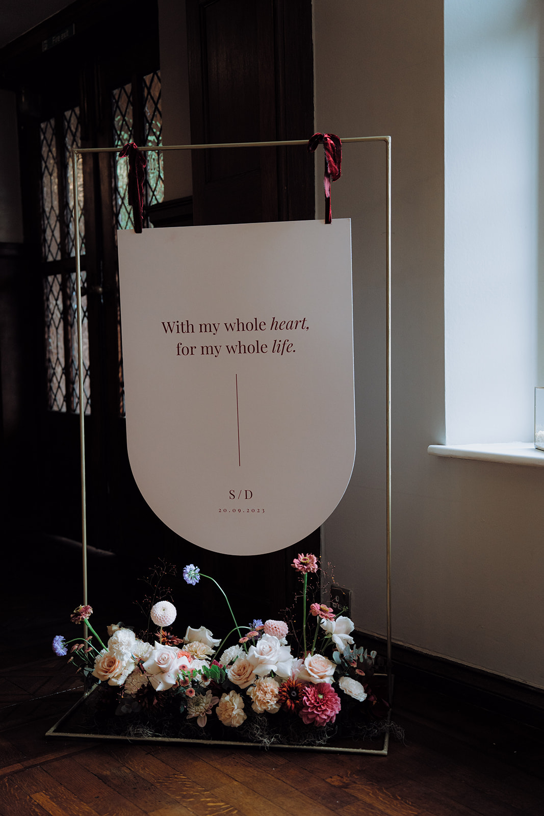 A wedding seating chart and table plan with flowers at the base.