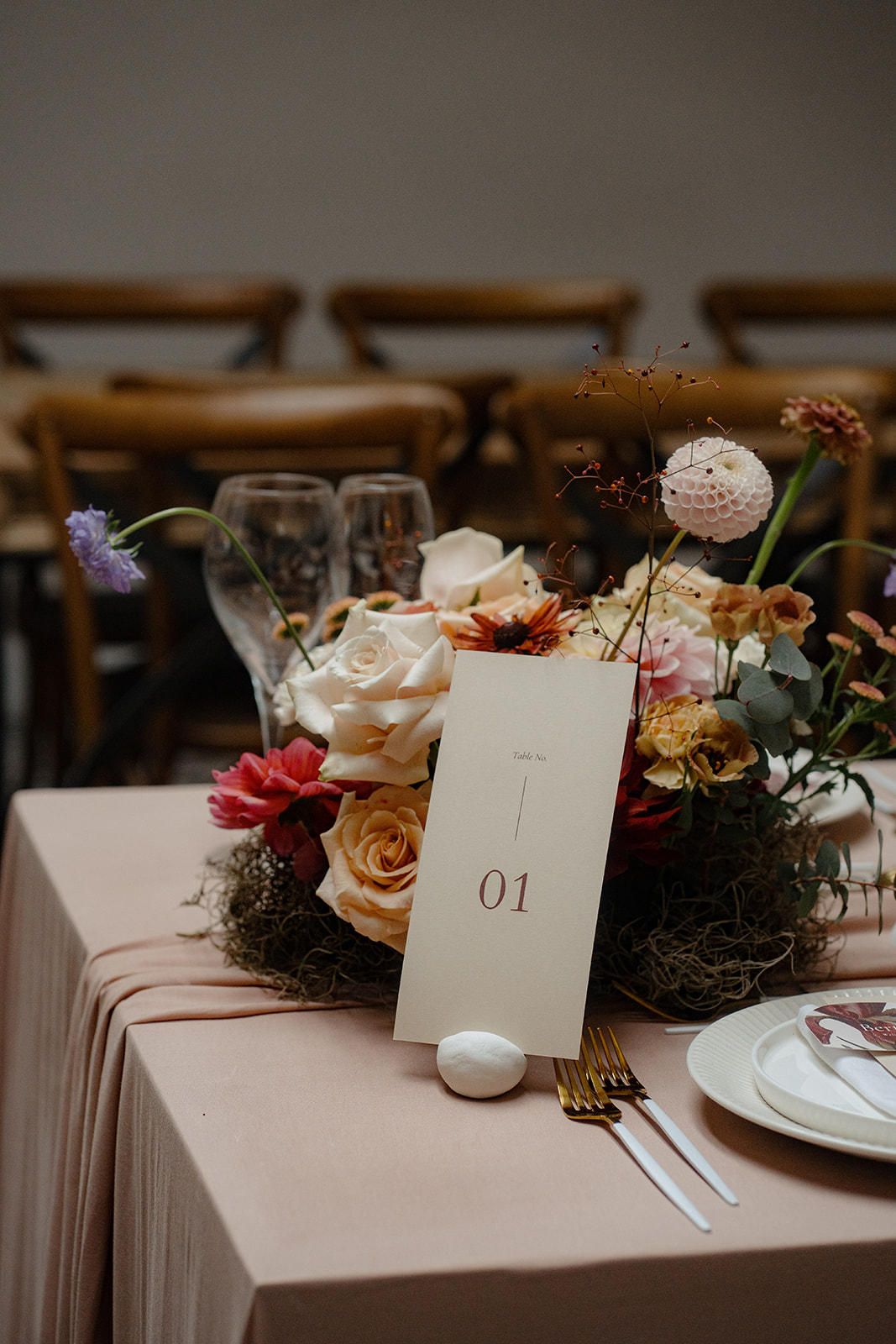 A white wedding cake surrounding with wedding flowers on a wooden table.