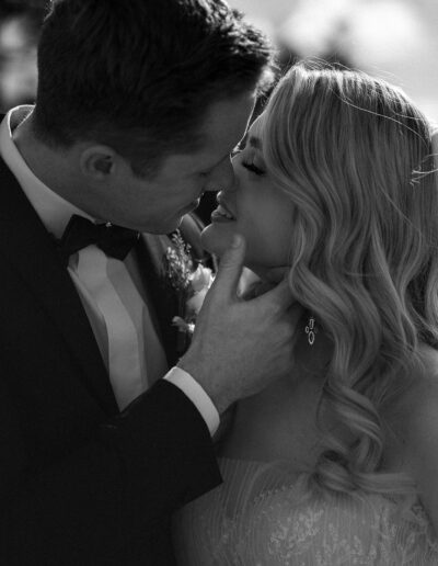 A black and white image of a bride and groom kissing for luxury wedding photography