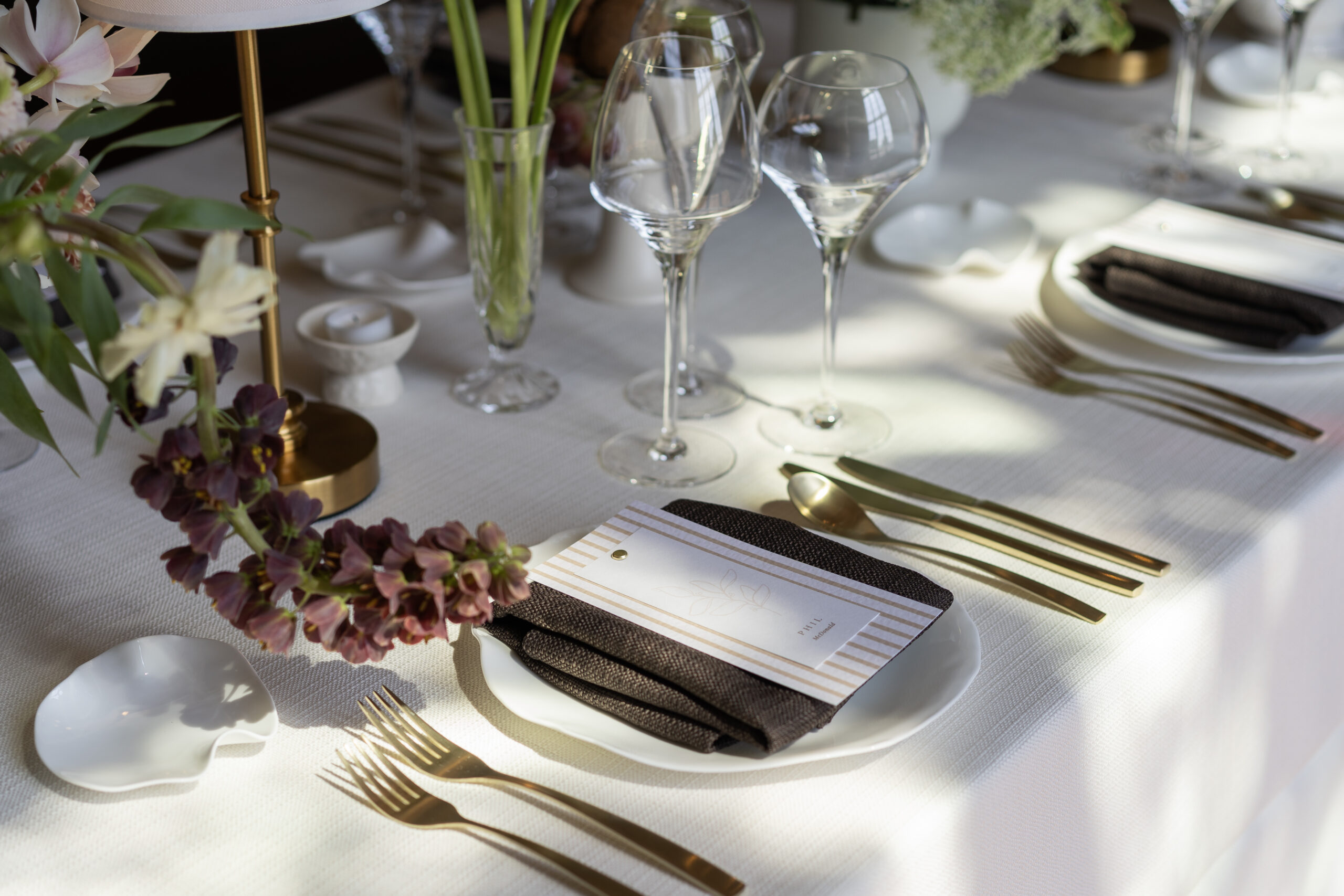 A colour image of a wedding design, styled on a wedding table with flowers.