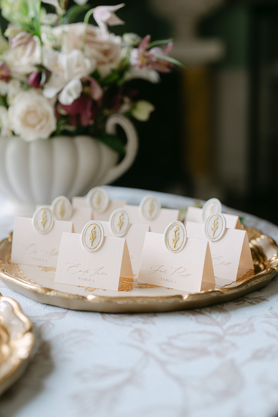 A colour image of wedding name place cards adorned with wax seals on a silver tray by Soiree Studio wedding planning.