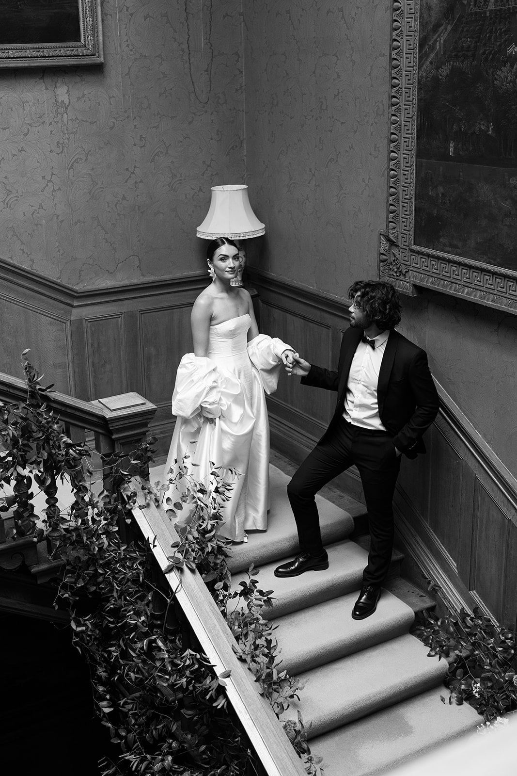 Birdsall House A black and white image of a couple standing at the top of the stairs at Birdsall House in Yorkshire. Wedding planned by Soiree Studio.