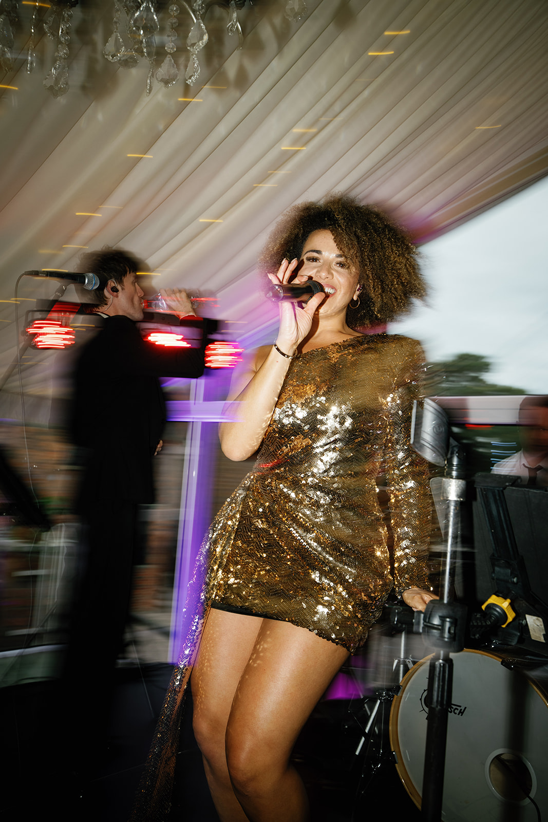 Madeleine & Chris A colour image of a wedding singer performing at a marquee wedding planned by Soiree Studio in Cheshire.