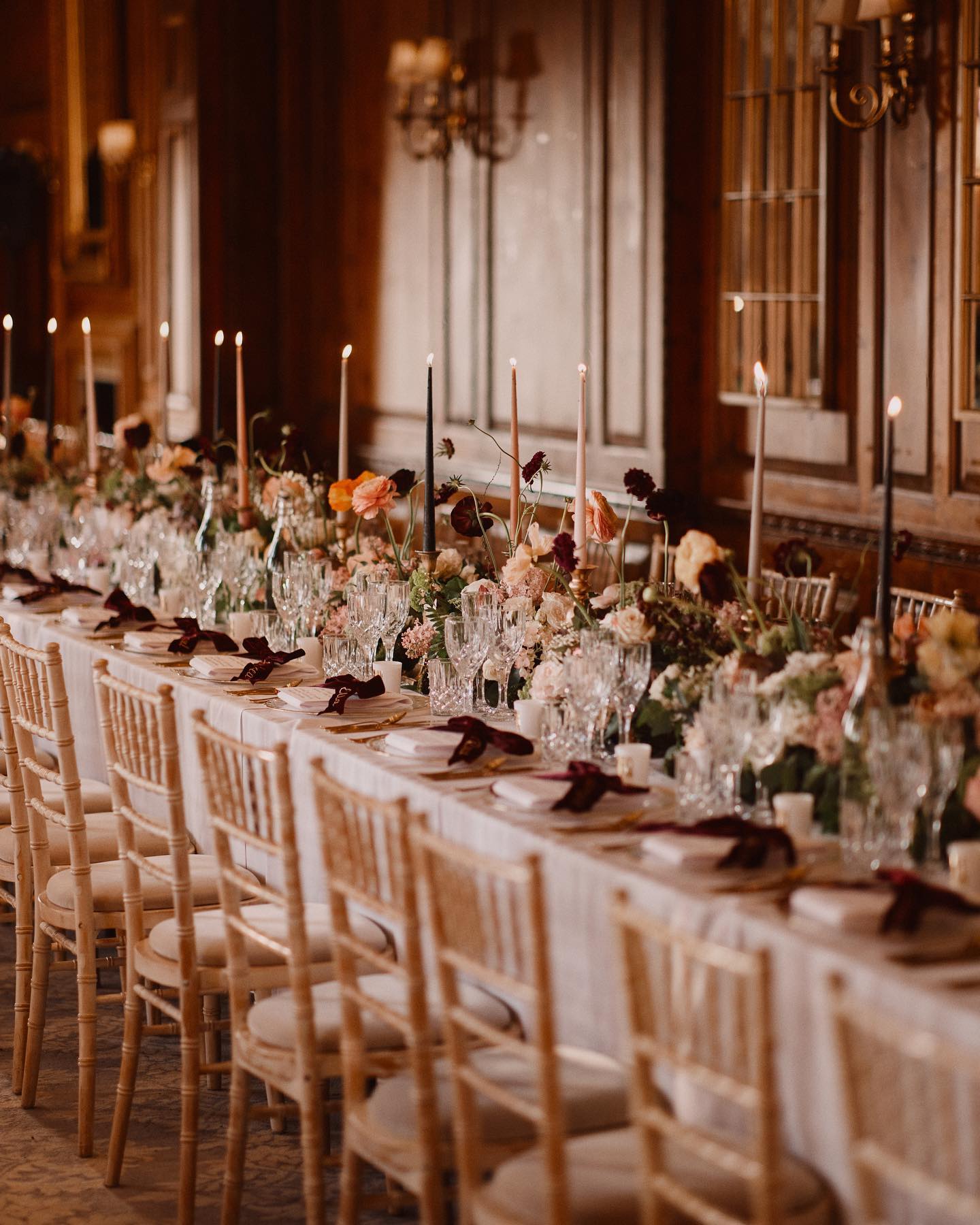 A colour image of beautiful wedding styled tables at Hedsor House ready for a wedding breakfast with calligraphy by Soiree Studio.