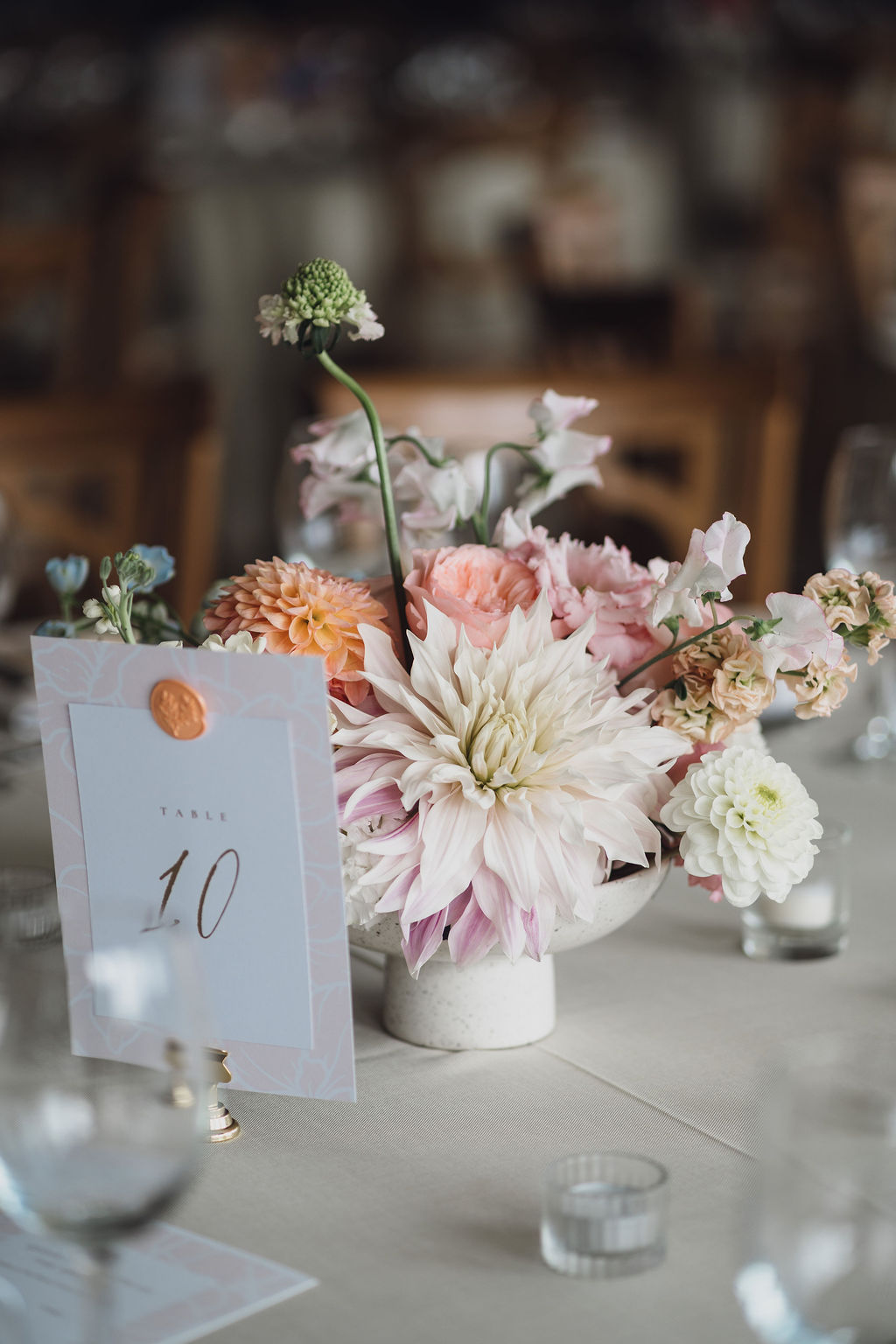 bespoke-wedding-stationery-marquee-wedding-planner-shropshire A colour image of a summer marquee wedding decor with peach flowers and table number in Shropshire.