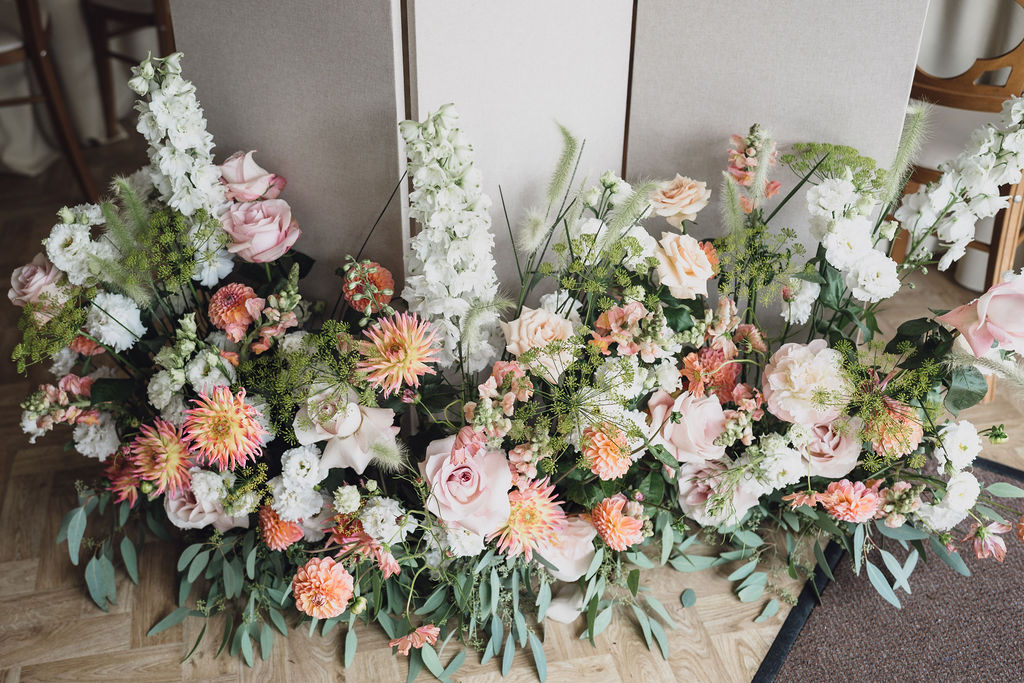 bespoke-wedding-table-plan-display-marquee-wedding-planner-shropshire A colourful image of beautiful summer wedding flowers in peach, soft pink and sage for a marquee wedding planned by design-led wedding planner Soiree Studio.