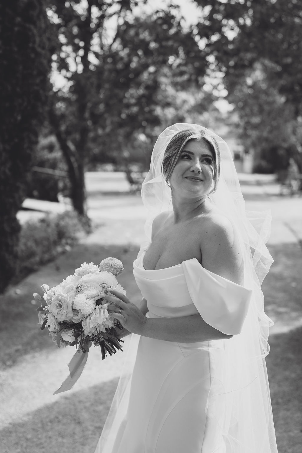 bridal-portrait-photography-wedding-planning-shropshire A black and white portrait image of a bride smiling with her bouquet at her marquee wedding in Shropshire planned by Soiree Studio.