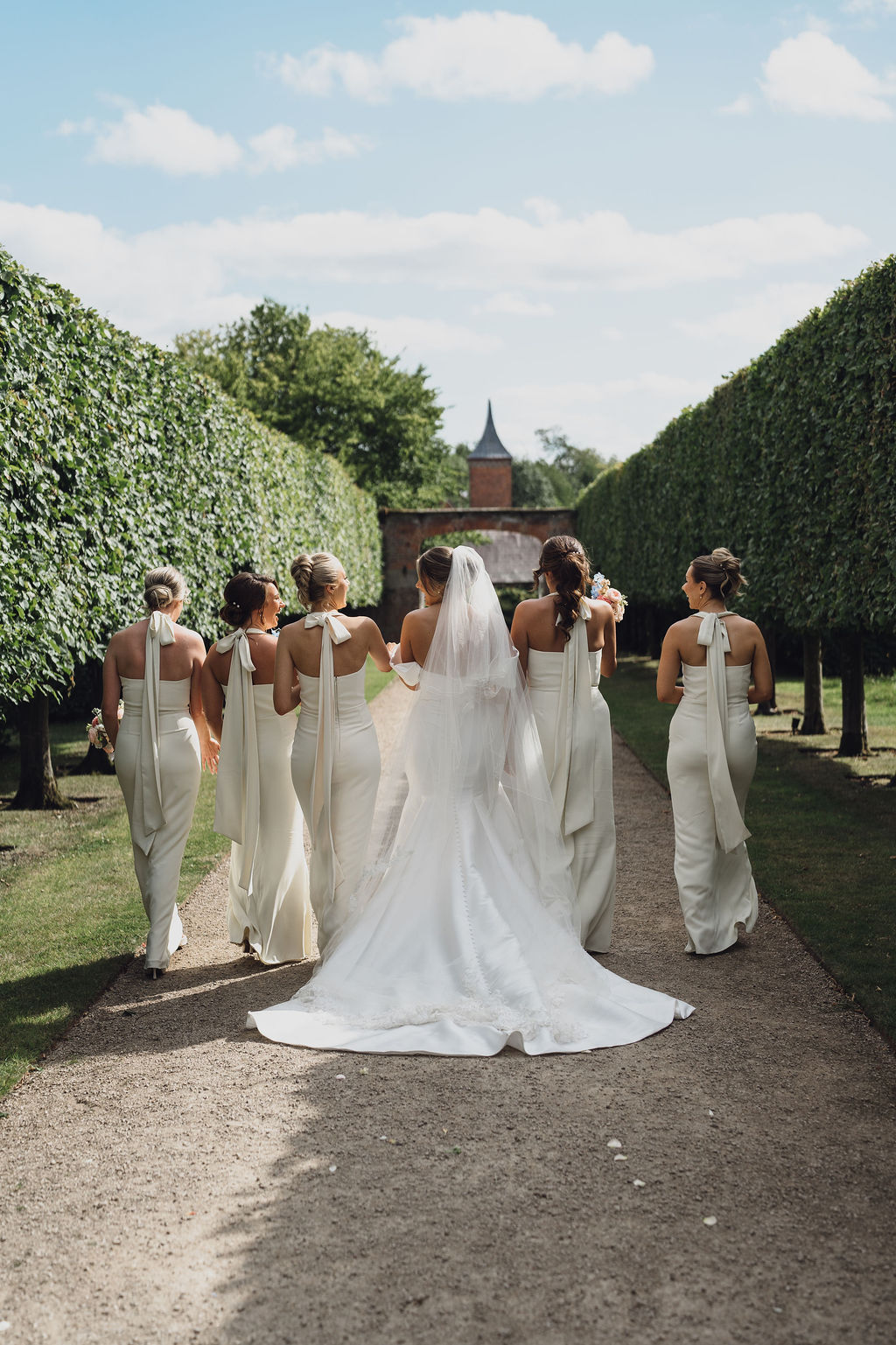 bride-and-bridesmaids-private-marquee-wedding-shropshire A colour image of a bride with her bridesmaids at Combermere Abbey in Shropshire with summer wedding bouquets.