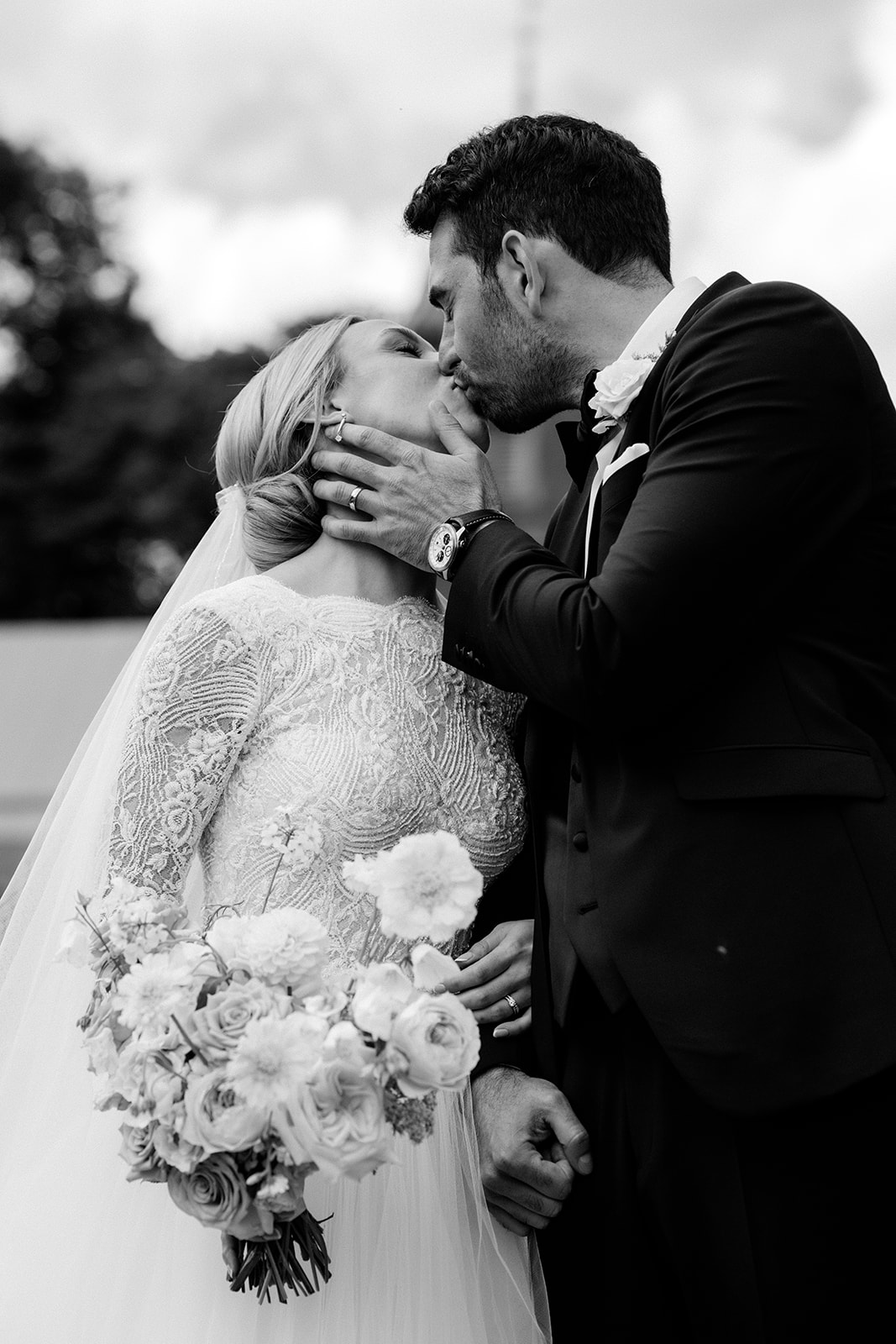 A black and white sage of a bride and groom kissing at Dorfold Hall Cheshire.