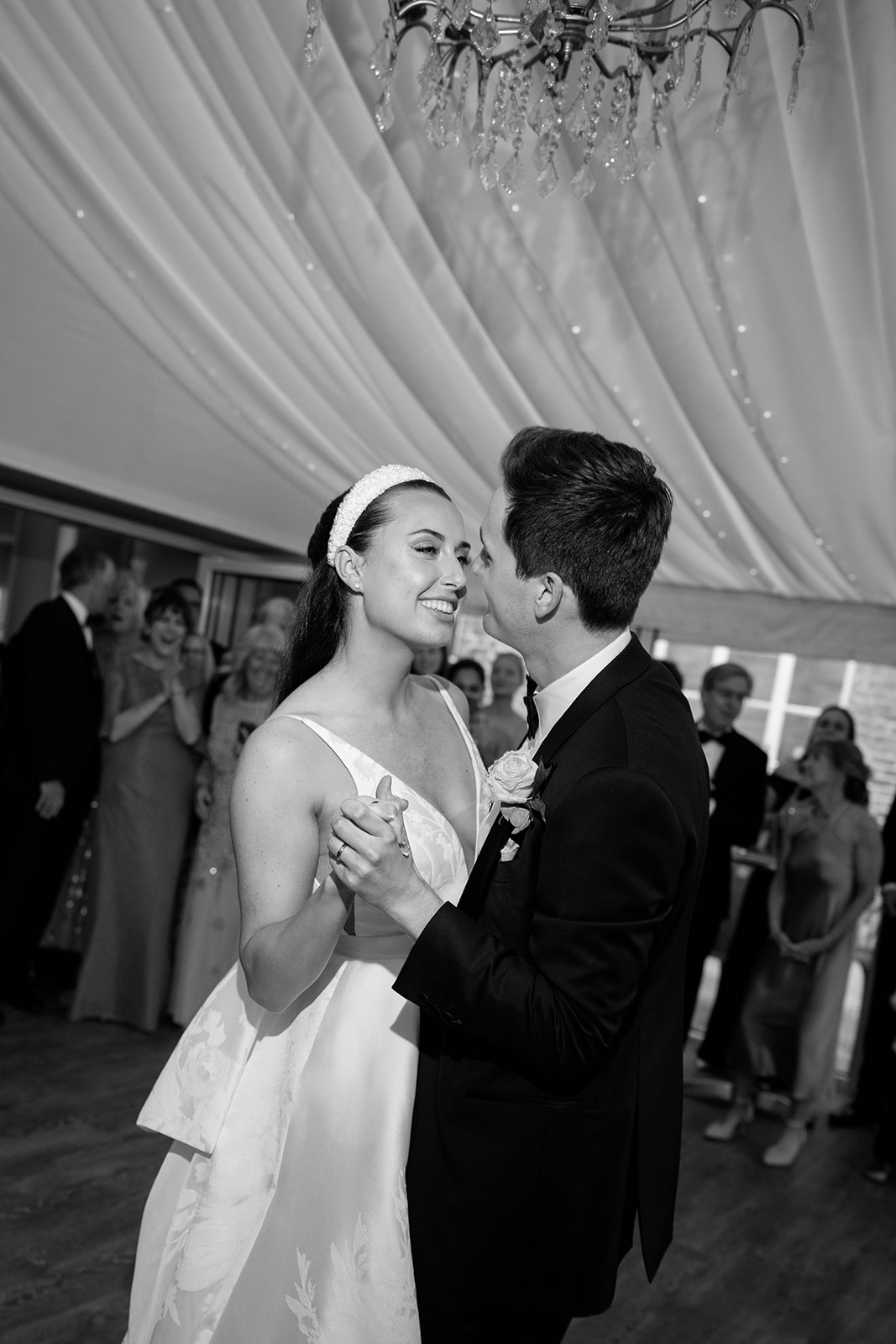 Madeleine & Chris A black and white image of a bride and groom having their first dance at their evening marquee wedding reception planned by Soiree Studio in Cheshire.