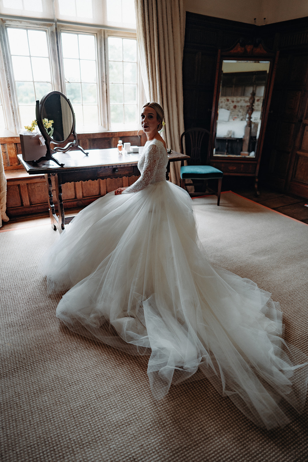 Amy and Jack A colour image of a bride in a beautiful flowing dress sat at a dressing table at Dorfold Hall in Cheshire.