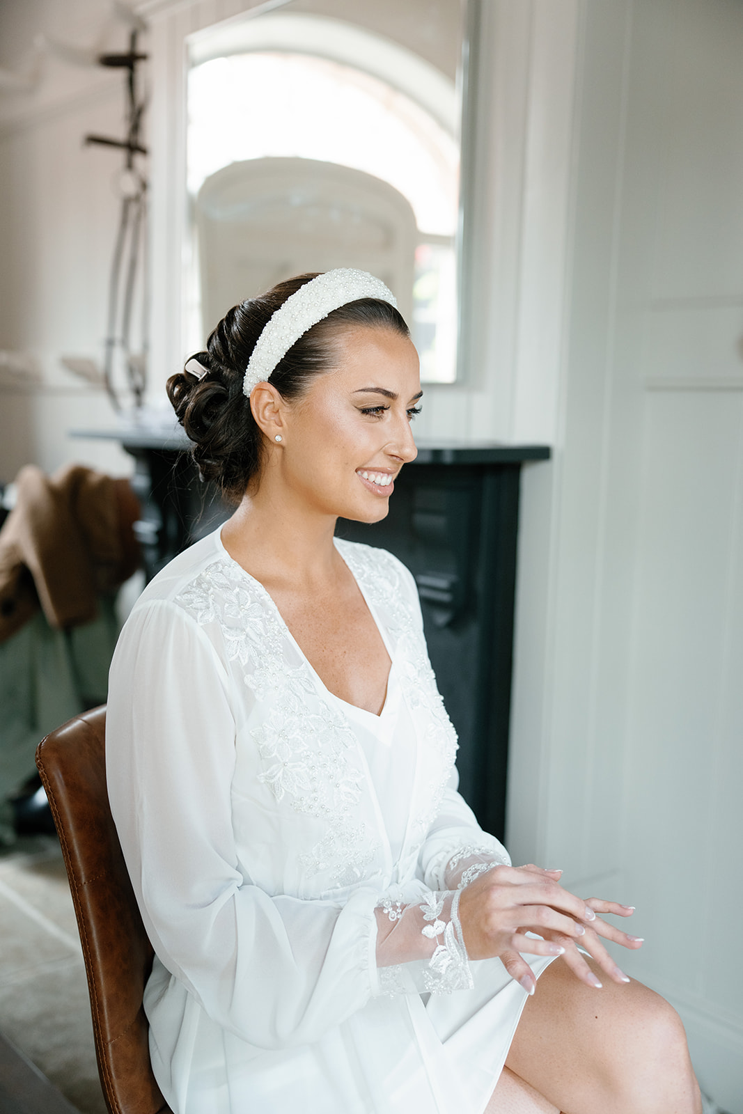 A colour image of a bride getting ready on her wedding morning after booking design led wedding planner Soiree Studio.