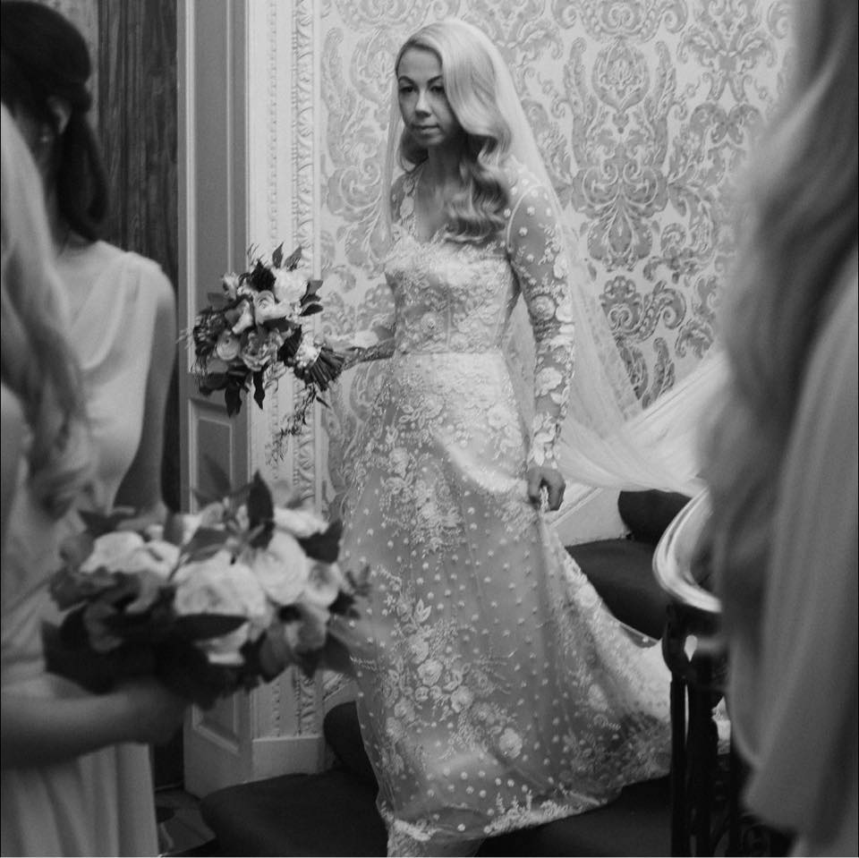 A black and white image of a bride walking down the stairs at Hedsor House for her wedding ceremony shot by Benjamin Wheeler in an editorial style.