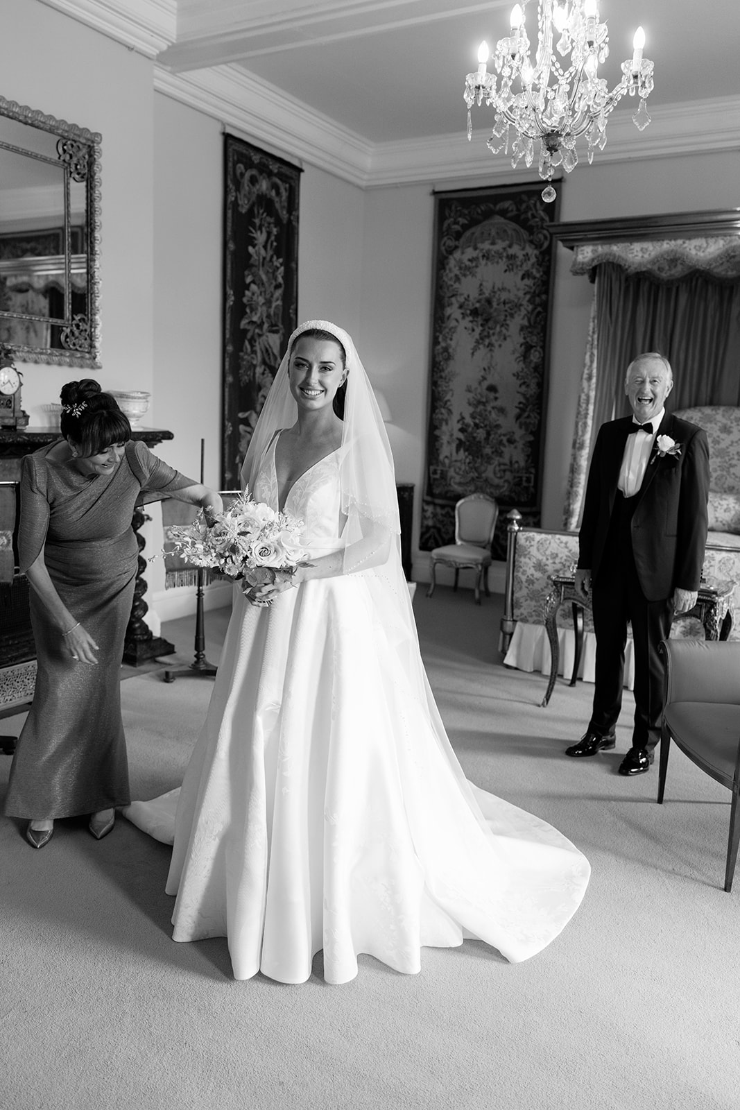 Madeleine & Chris A black and white image of a bride with her parents at Capesthorne Hall Cheshire wedding venue.
