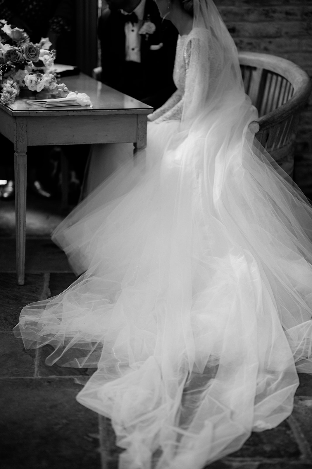 Amy and Jack A black and white image of a bride and groom writing in the marriage register at their church wedding in the Cotswolds.