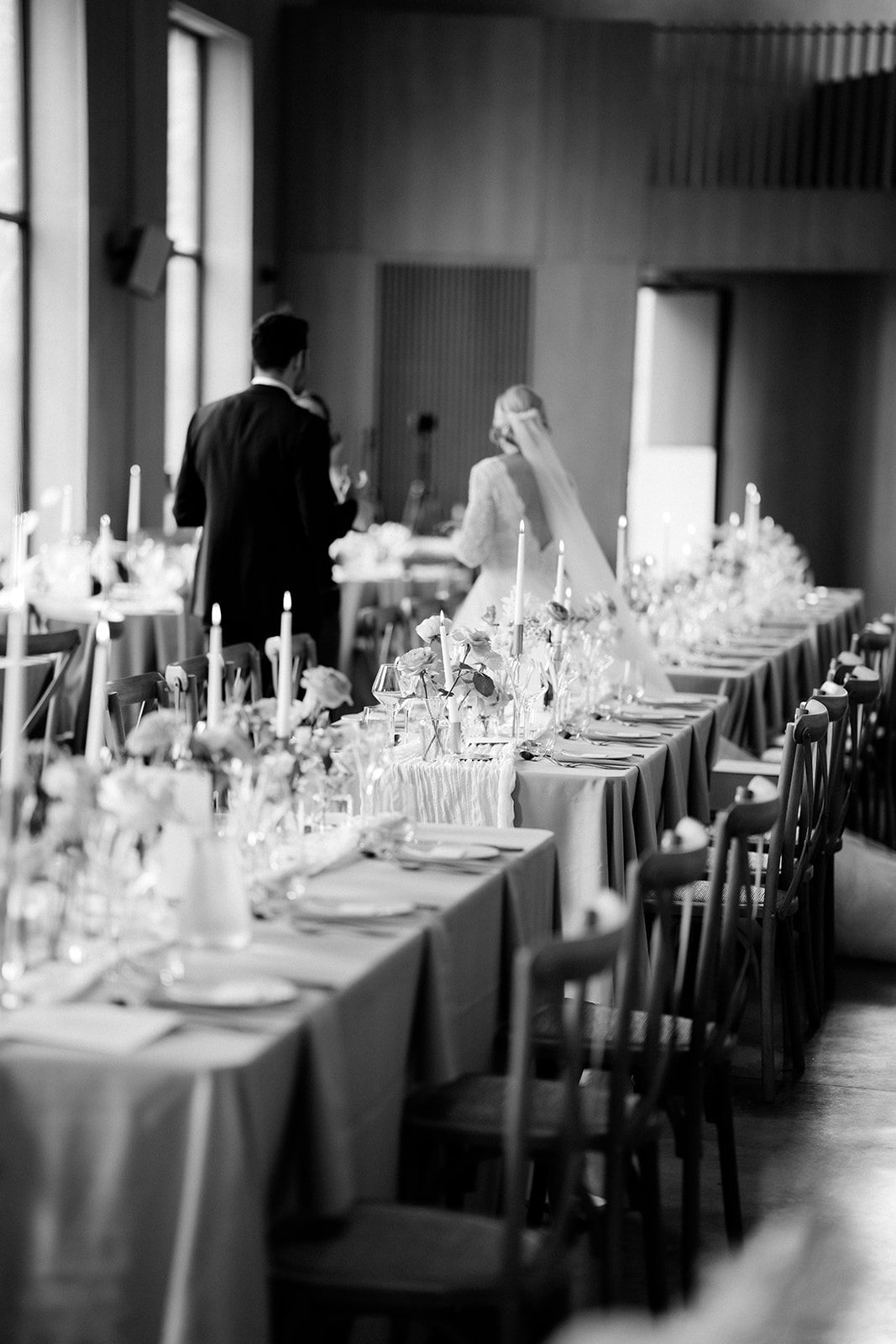 Amy and Jack A black and white image of the bride and groom taking a first look at their wedding reception tables at Dorfold Hall in Cheshire.