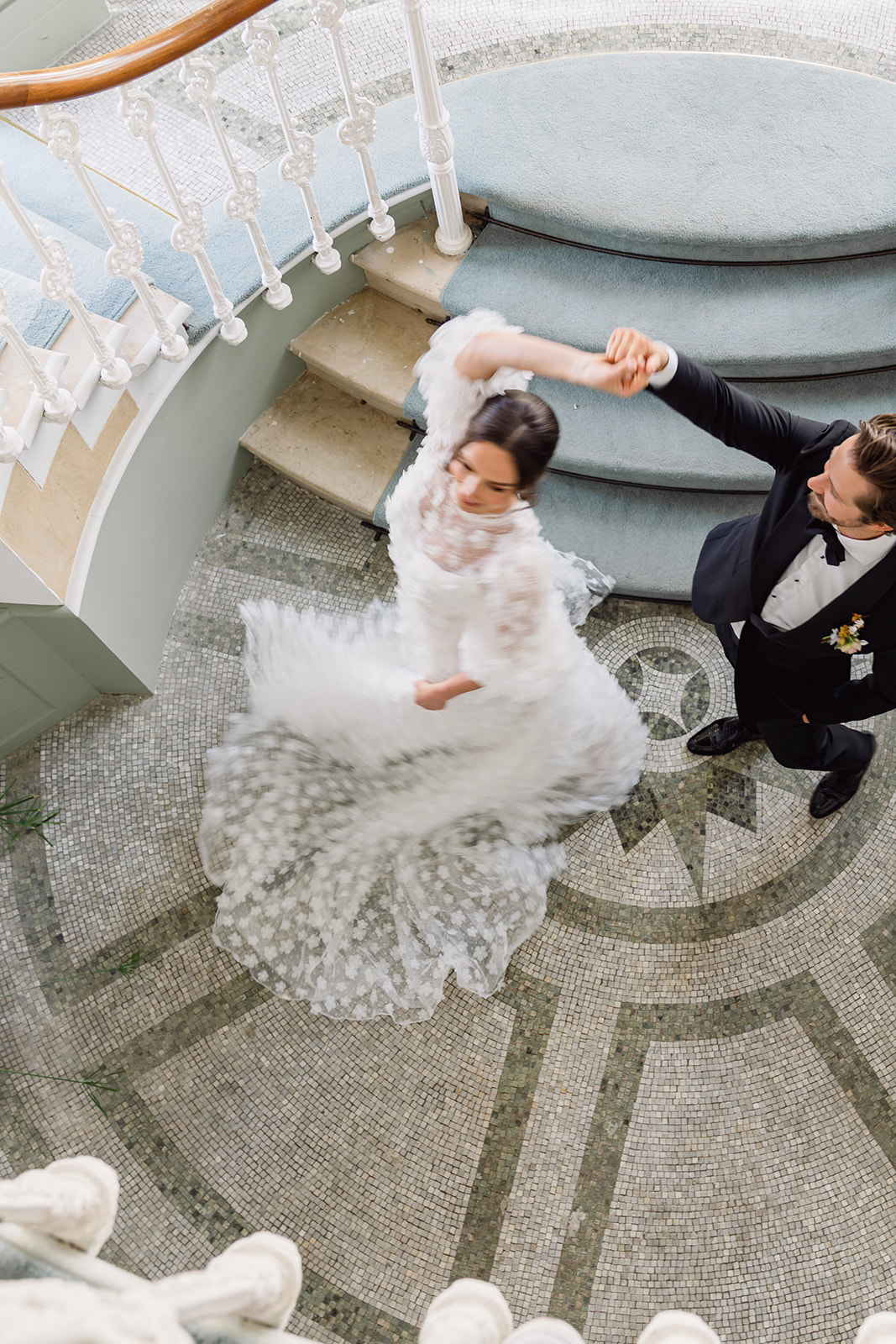 A colour image of a bride and groom dancing at the bottom of the stairs at Hawkstone Hall in Shropshire.