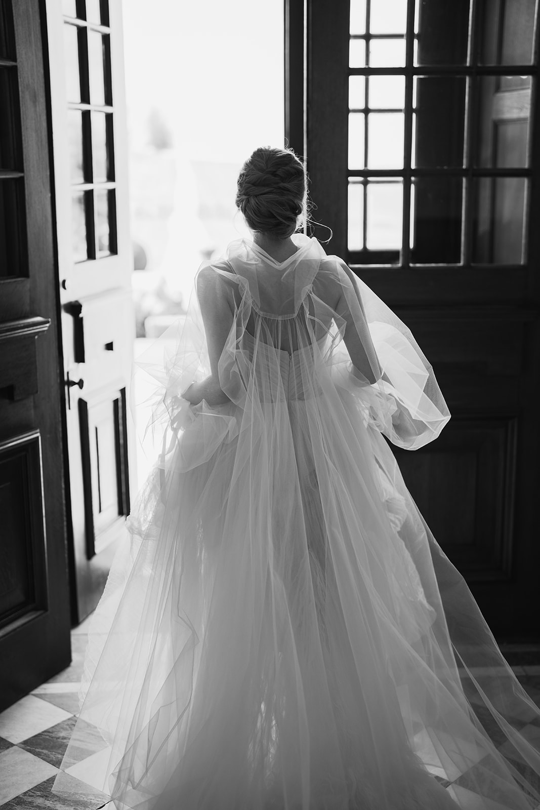A black and white image of a bride wearing an elegant floaty wedding dress at Hawkstone Hall wedding venue.