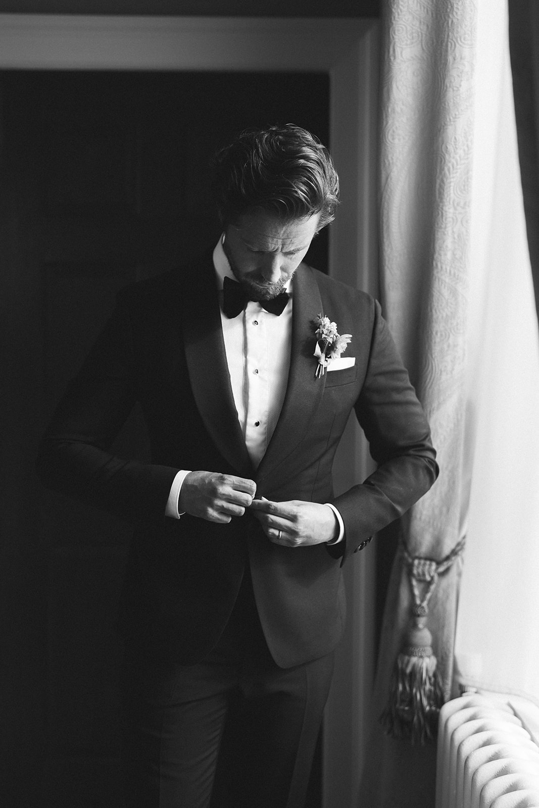 A black and white image of a groom getting ready at Hawkstone Hall Shropshire.
