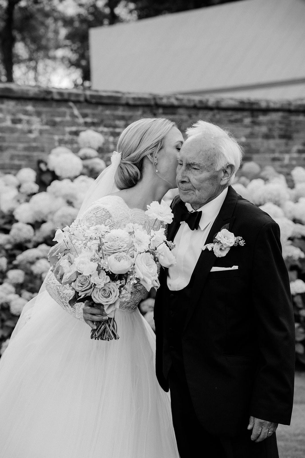 Amy and Jack A black and white image of a bride having a quiet moment with her grandfather after her wedding ceremony at Dorfold Hall in Cheshire