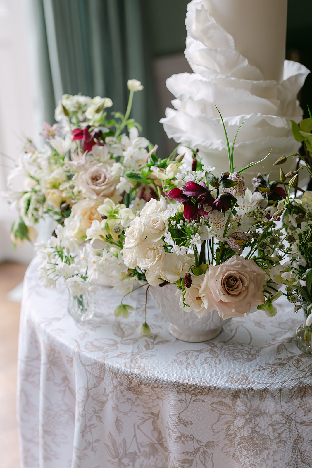 Birdsall House A colour image of a wedding cake adorned with spring fresh flowers at Birdsall House in Yorkshire planned by soiree studio.