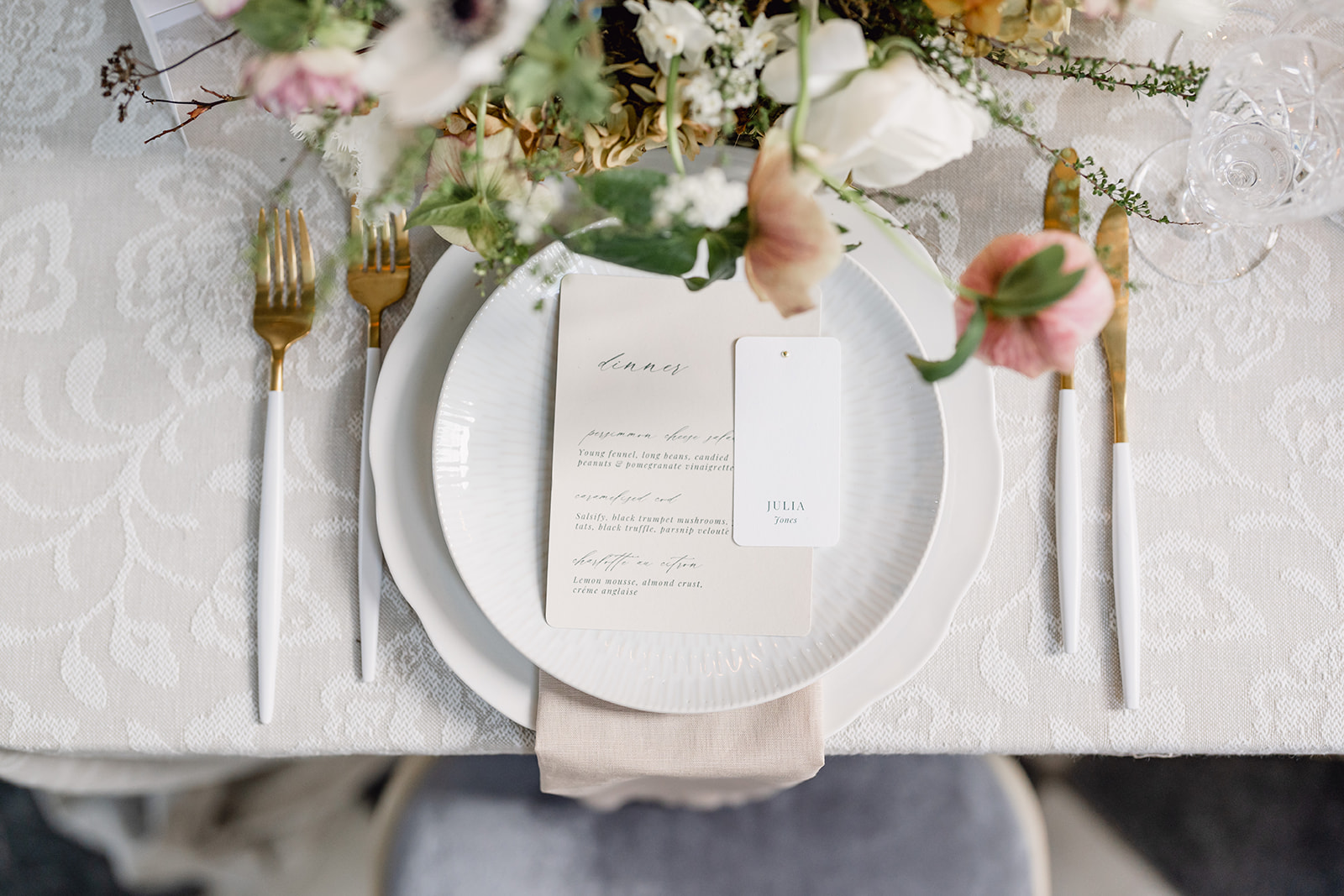 Hawkstone Hall Editorial // Petite Dauphine A colour image of a spring inspired wedding place setting with daffodil, neutral patterned table cloth, styled at Hawkstone Hall by Wedding Planner Soirée Studio.