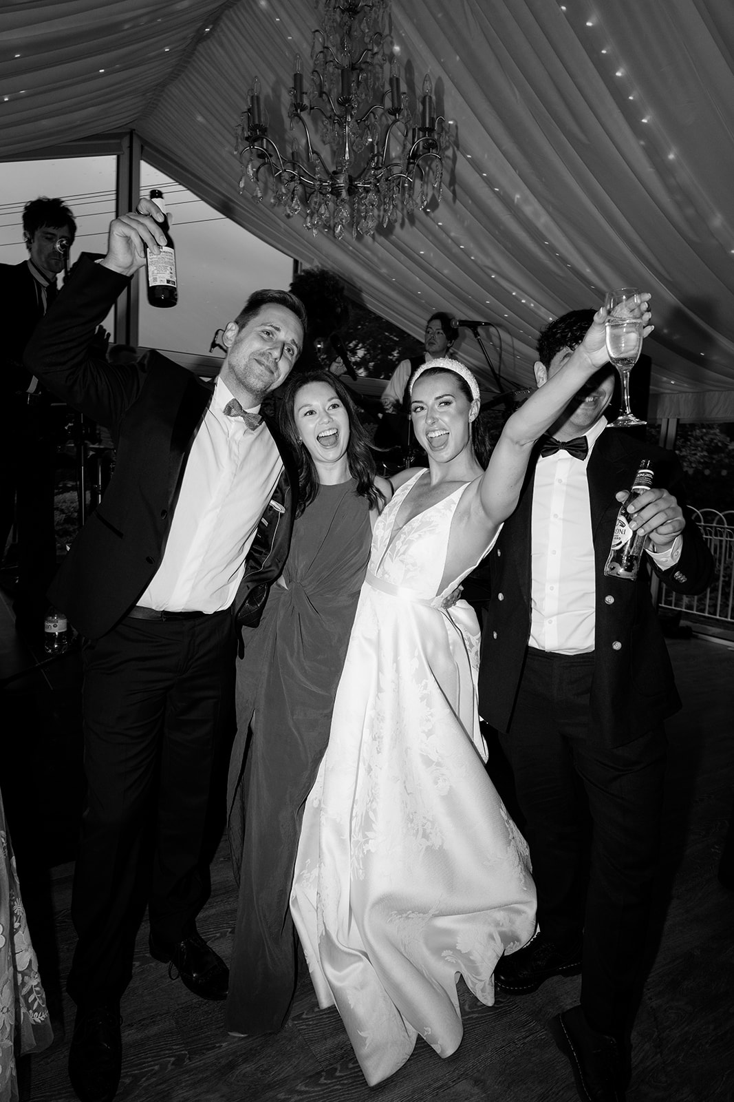 Madeleine & Chris A black and white image of a bride with her friends celebrating at her marquee wedding in cheshire.