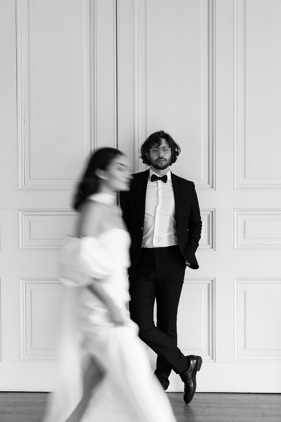 Birdsall House A black and white image of a couple at Birdsall House in Yorkshire with the bride walking past the groom in a blurred editorial style.