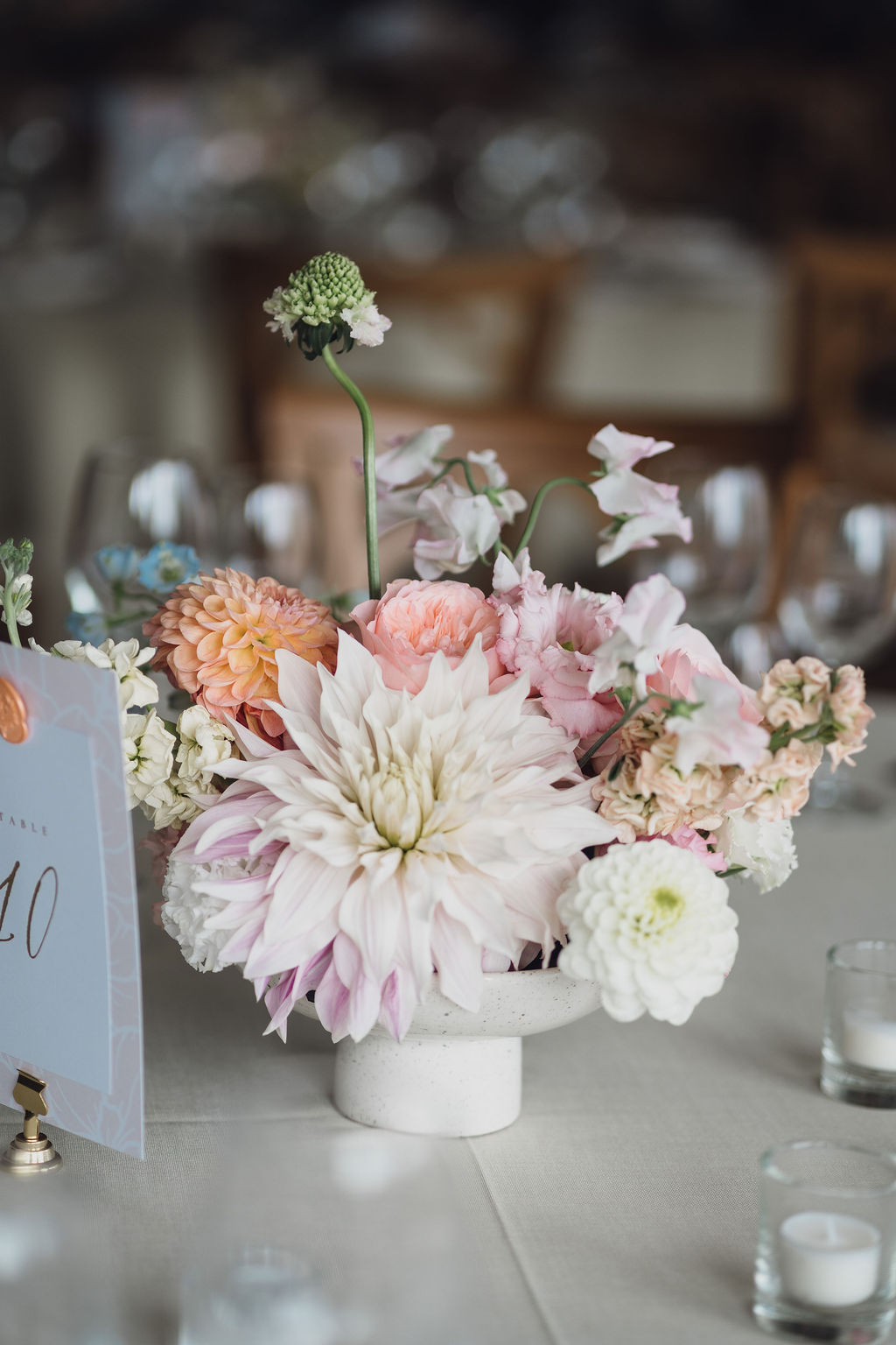 summer-marquee-wedding-floristry-shropshire A colour image of summer wedding flowers with peach and pink tones at a wedding planned by design-led wedding planner soiree studio.