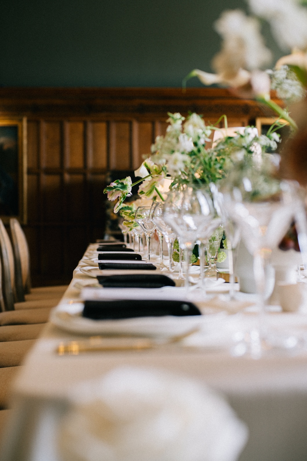table-styling-design-led-wedding-planner-cheshire A colour image of a long wedding dining table with white table linen and mocha napkins by design led wedding planner soiree studio.