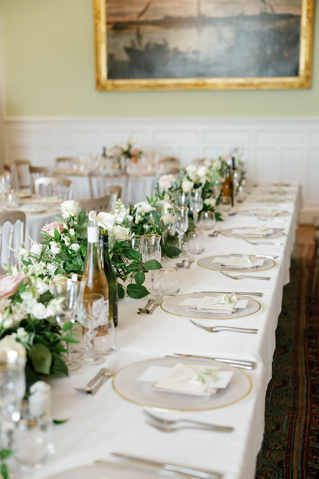 Madeleine & Chris A colour image of a long top table with neutral linen and fresh foliage.