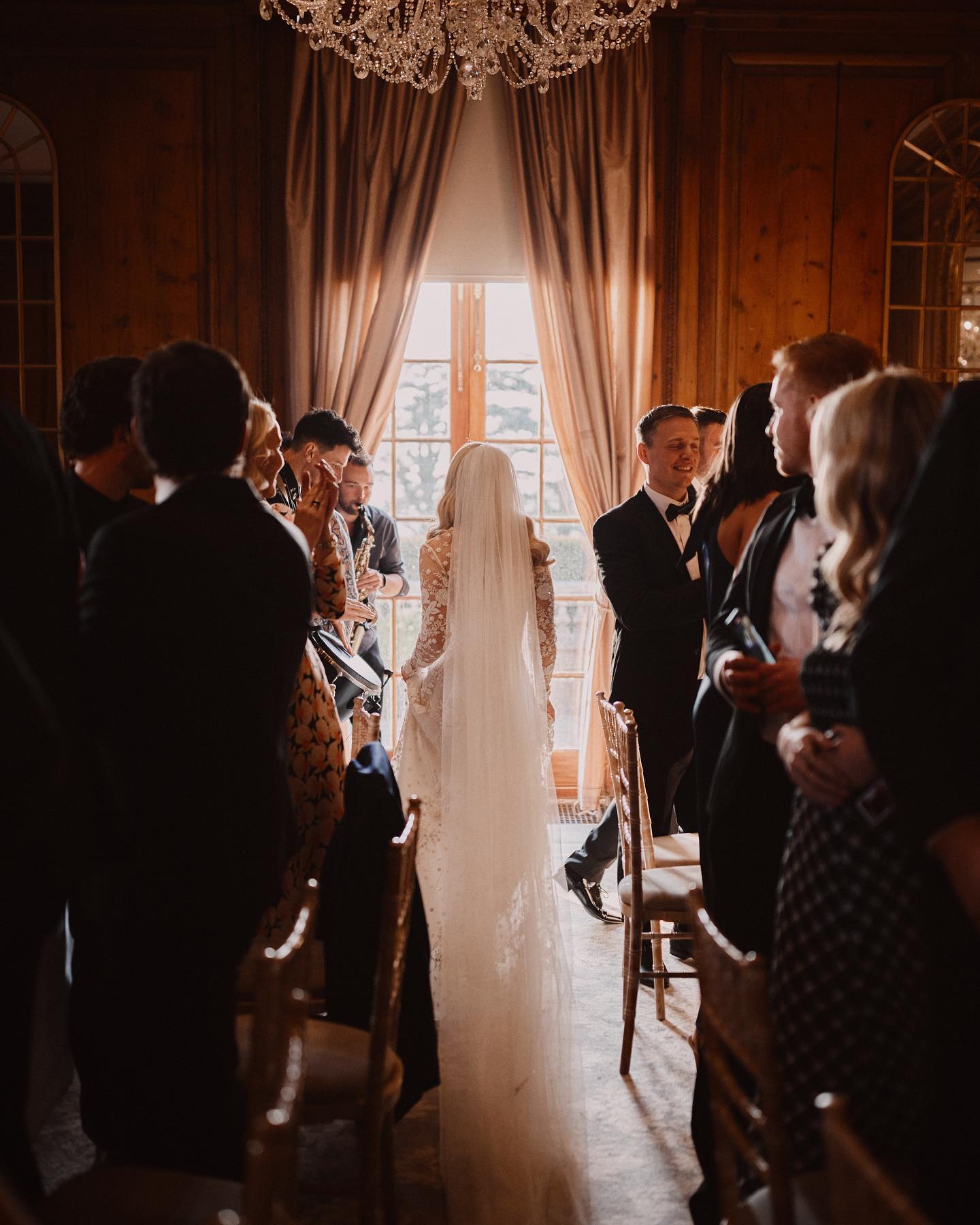 A colour image of a bride looking out of the wedding at Hedsor House after her wedding ceremony by Benjamin Wheeler.
