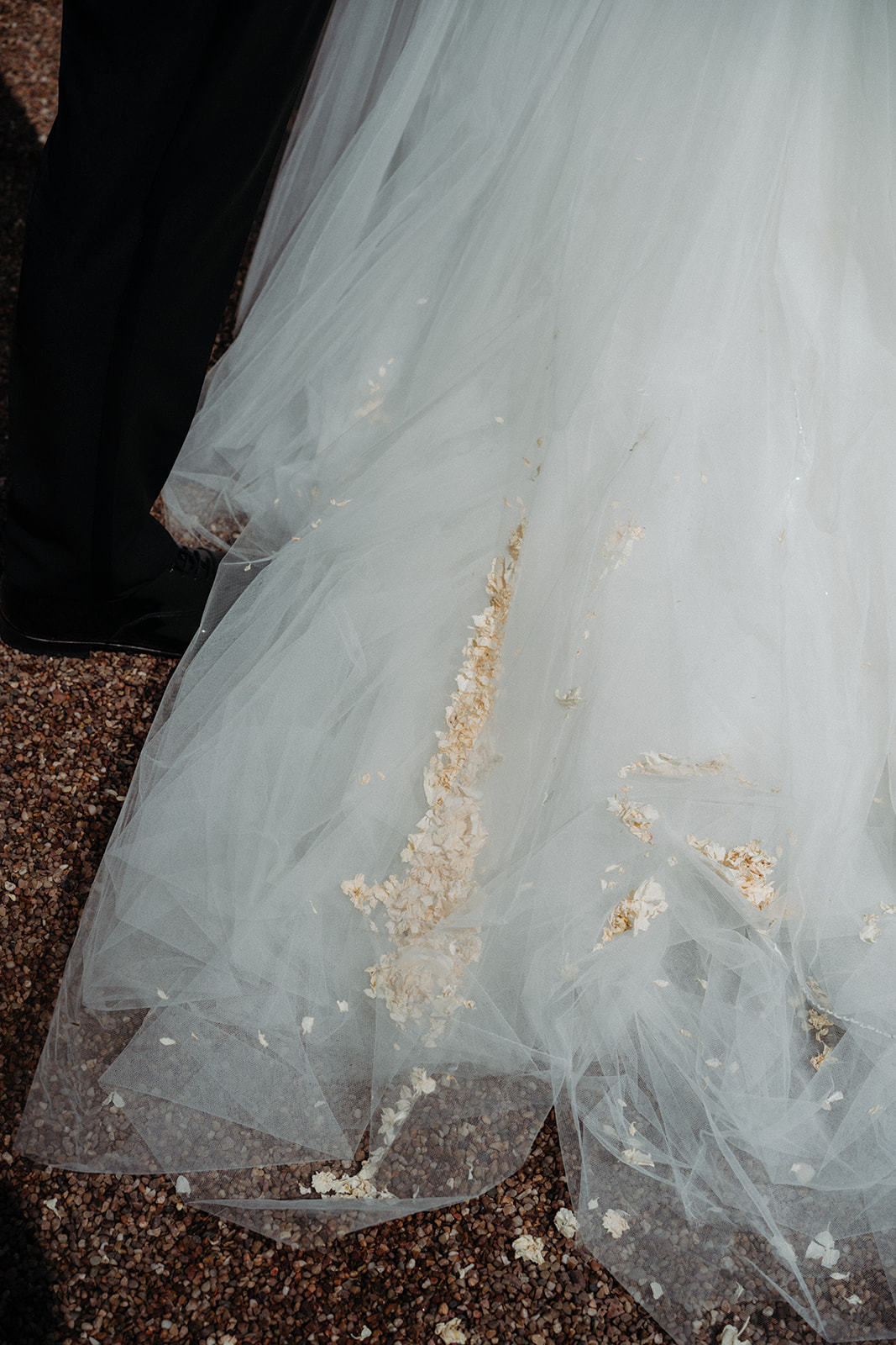 Amy and Jack A colour image of confetti at the base of a brides dress after her wedding ceremony at Dorfold Hall in Cheshire.