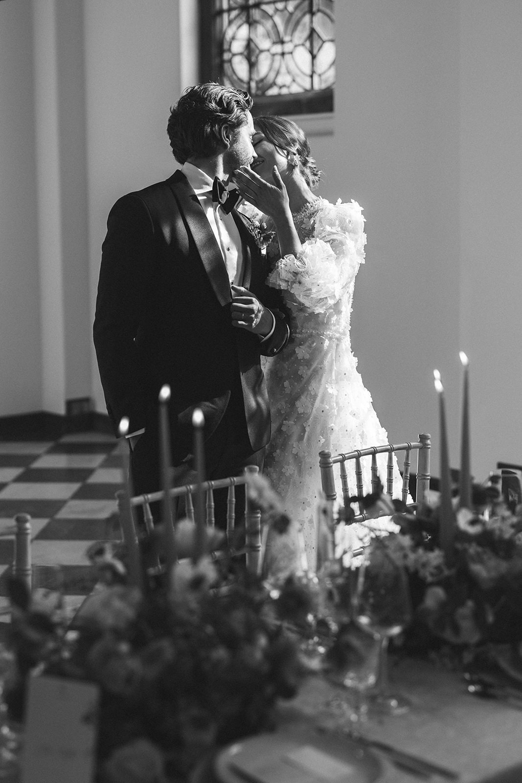 A black and white sage of a couple sharing a kiss at their wedding reception planned by Soiree Studio at Hawkstone Hall Shropshire.
