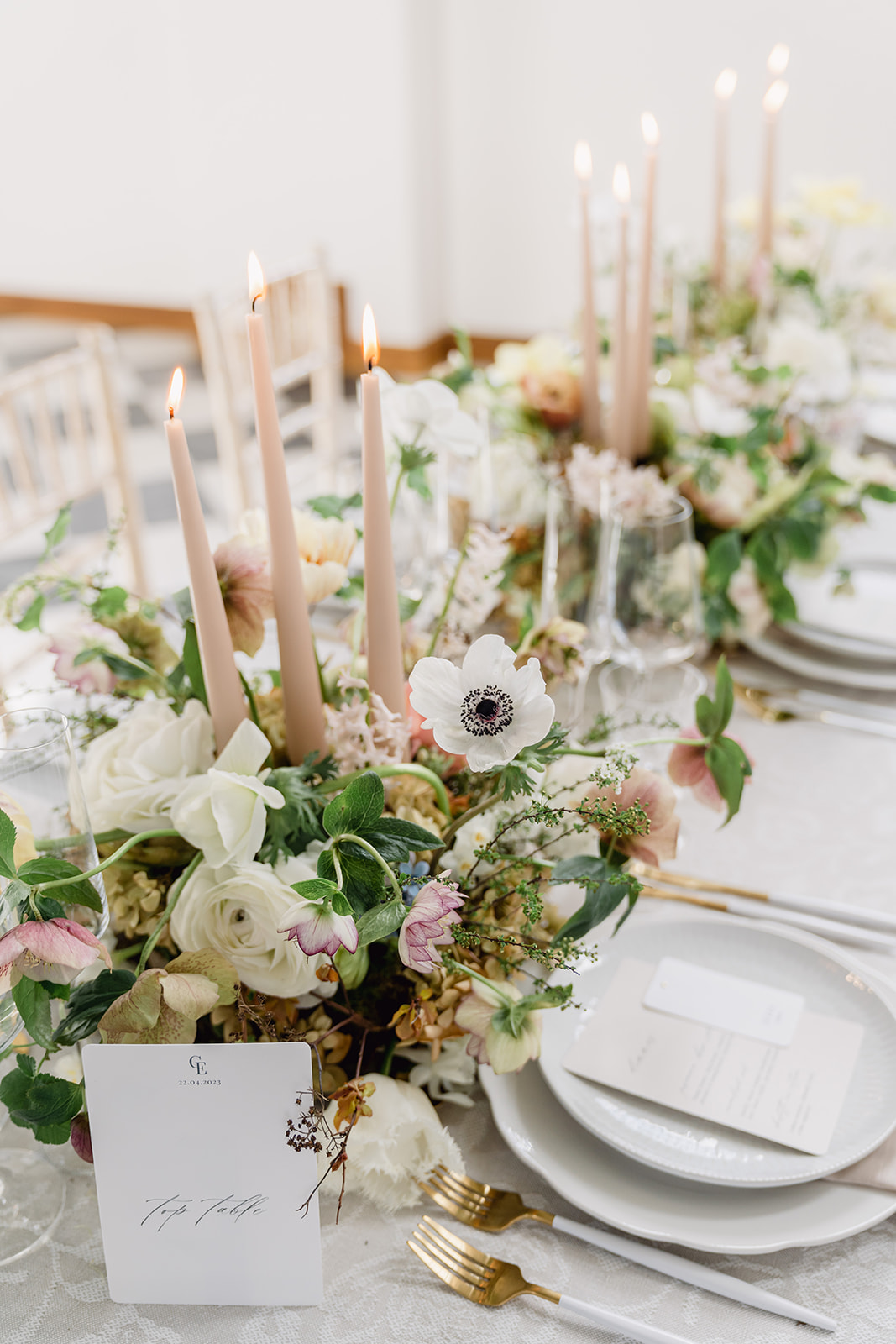 A colour image of a spring wedding table with tall caramel coloured tapered candles at a wedding planned by soiree studio at Hawkstone Hall.