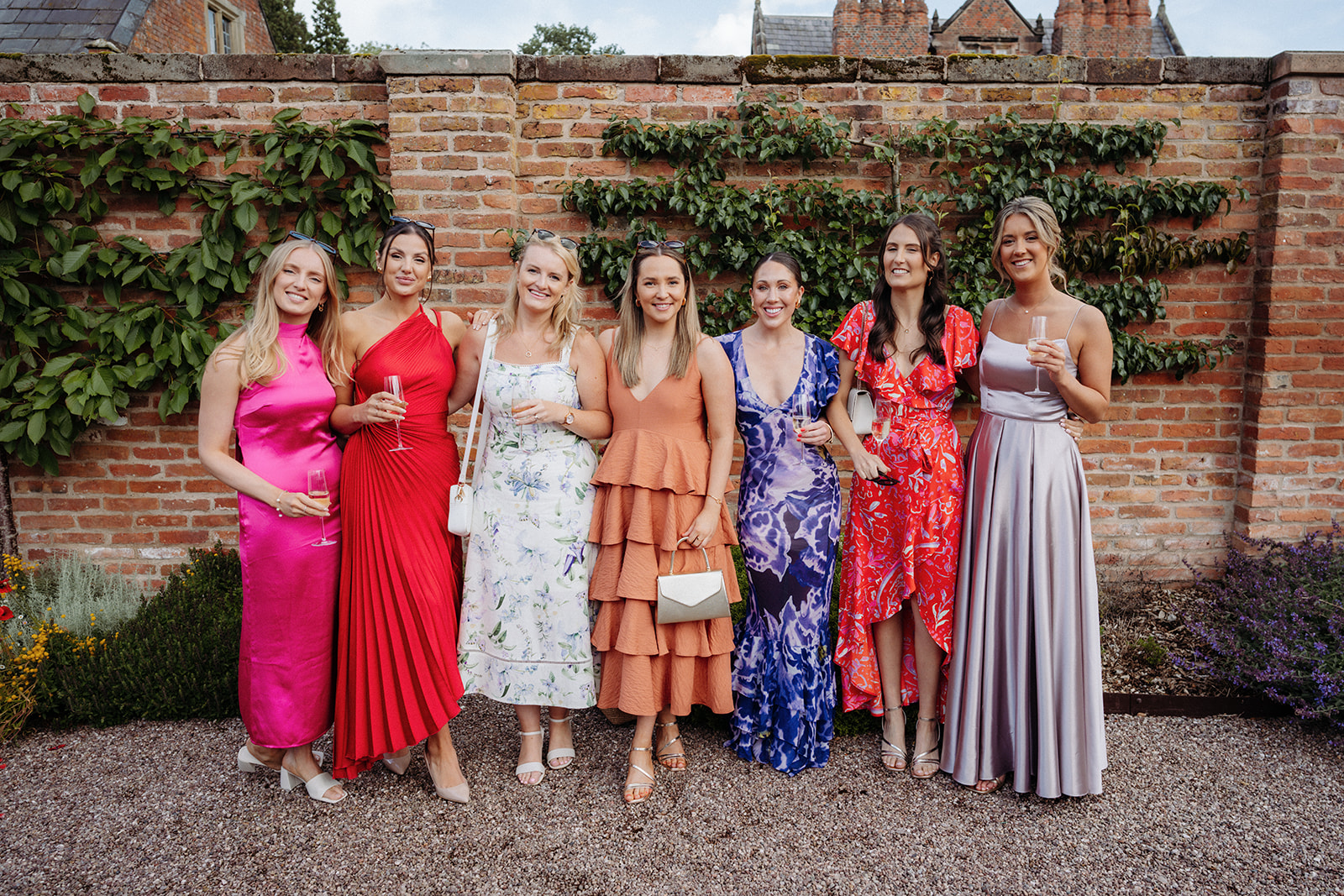 Amy and Jack A colourful image of guests in beautiful summer dresses at a wedding at Dorfold Hall in Cheshire.
