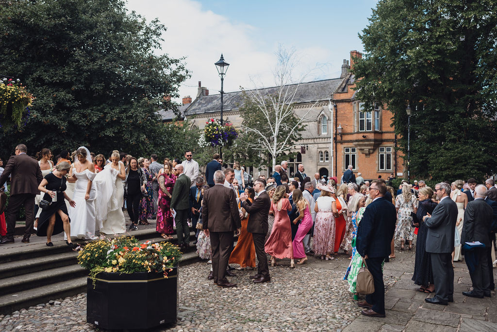 wedding-guests-outside-nantwich-church-shropshire-wedding-planner A colour image of wedding guests gathering outside Nantwich church in Shropshire for a summer wedding.