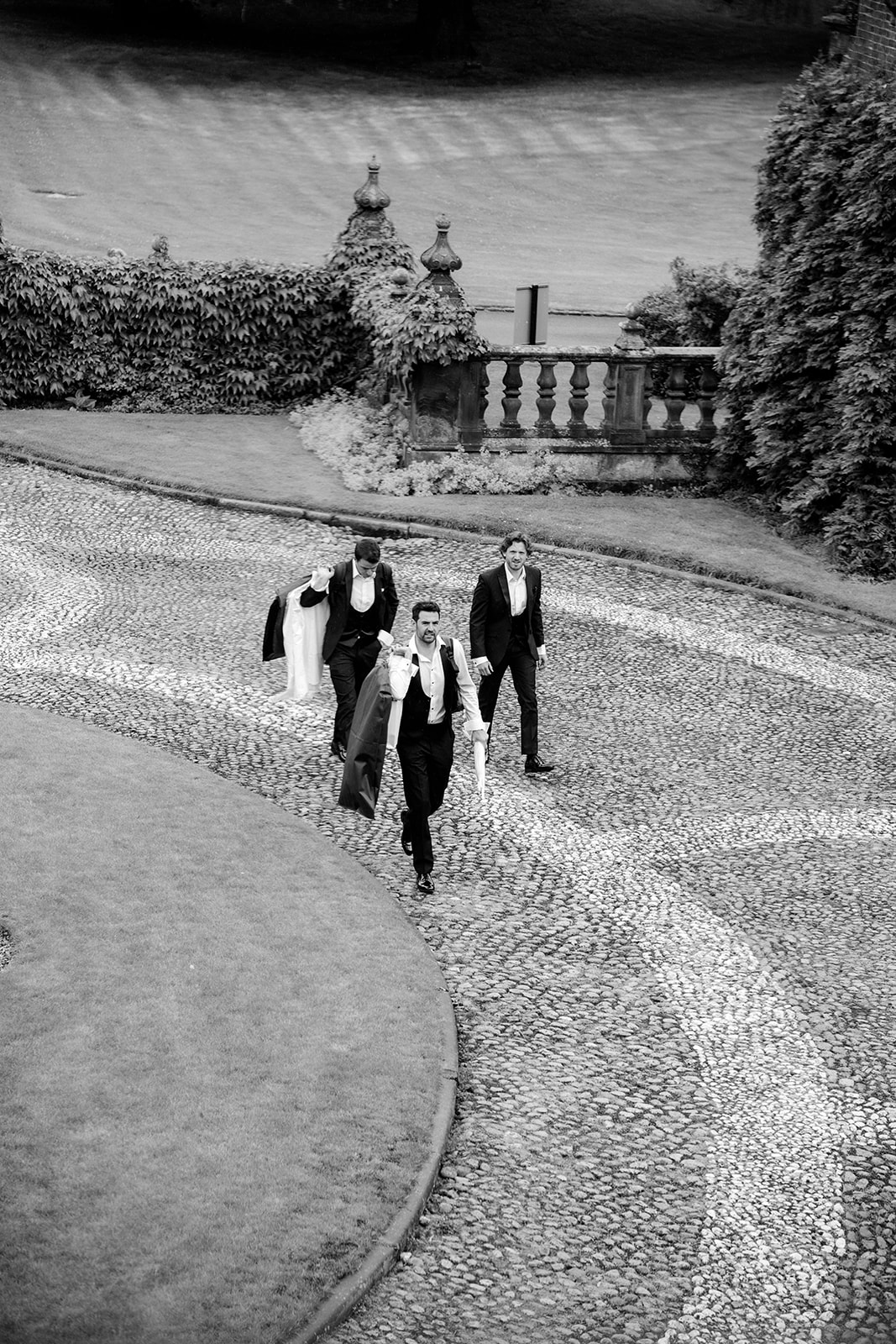 Amy and Jack A black and white image of the bridal party arriving ready in their suits for the wedding ceremony at Dorfold Hall Cheshire.