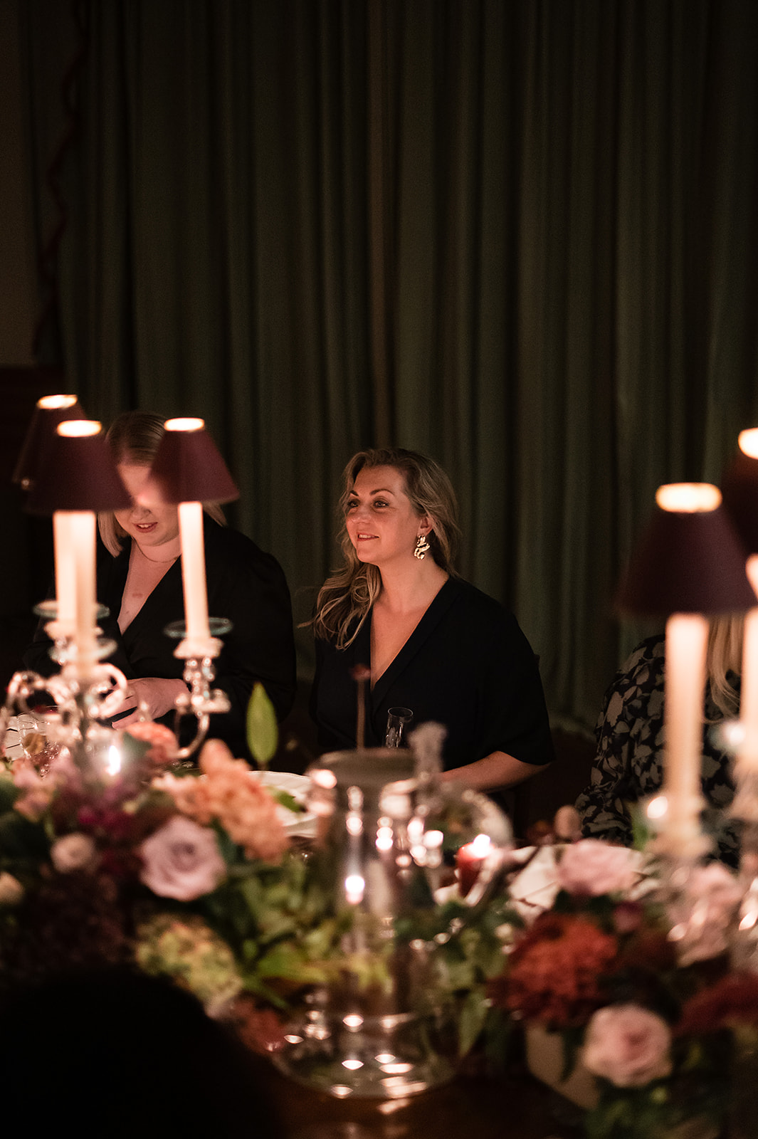 A colour image of a bride and groom stood behind their top table at Birdsall House in Yorkshire.