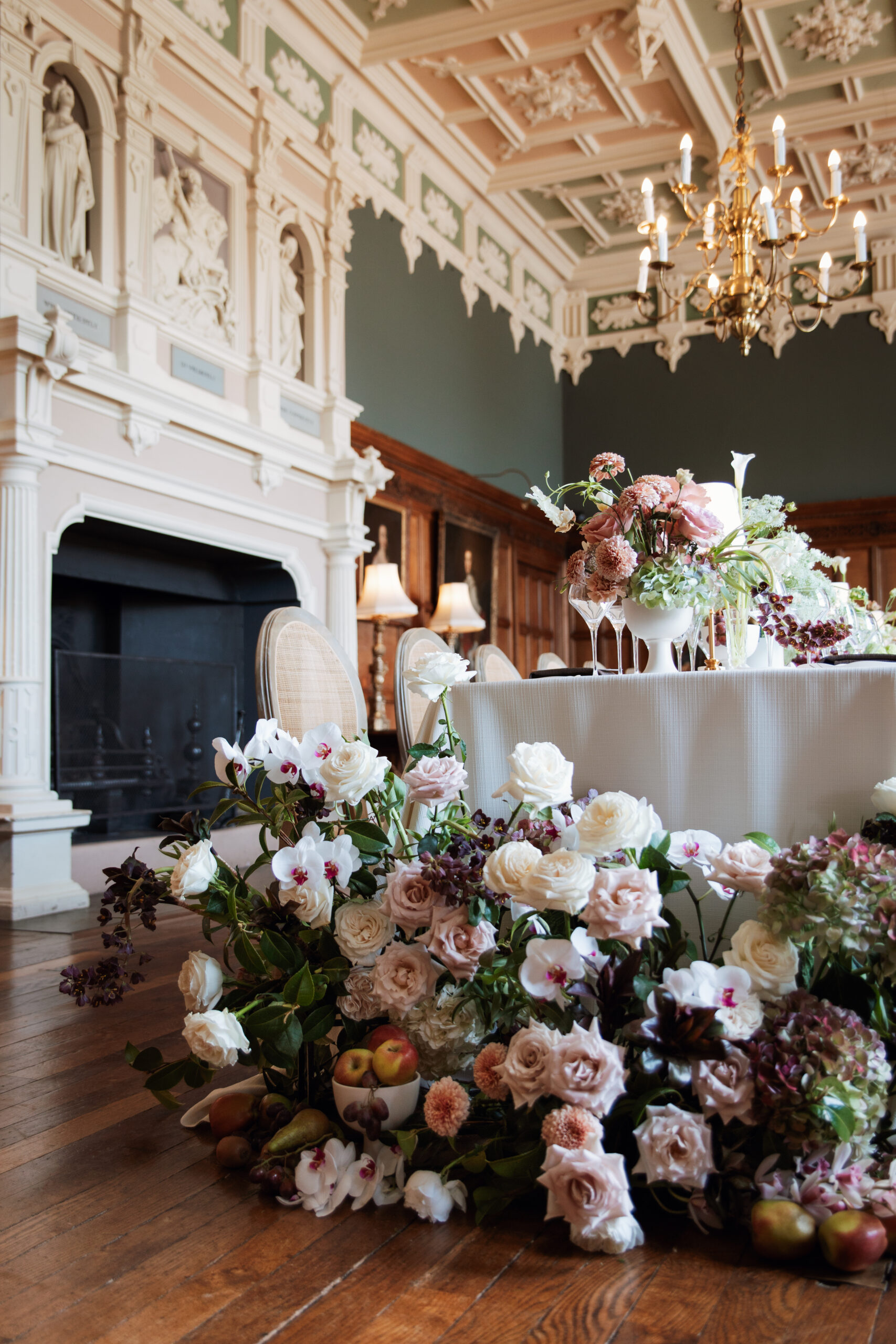 A colour image of a large wedding floral installation at the end of a wedding dining table at Arley Hall Cheshire.
