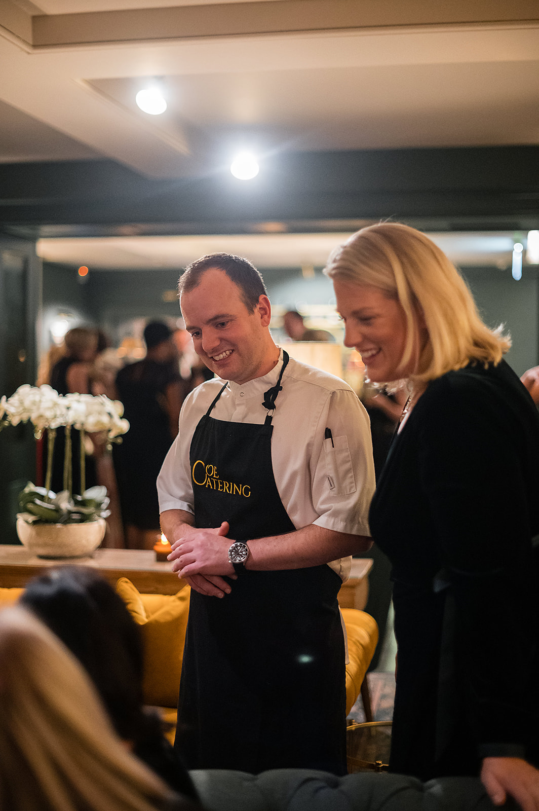 A black and white image of a bride and groom enjoying a cocktail in martini glasses at their marquee wedding planned by soiree studio.