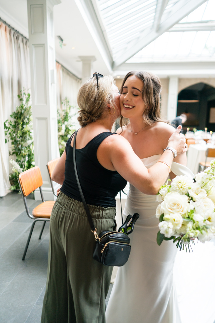 A colour portrait image of a bride and groom looking at each other outside Combermere Abbey in Shropshire.