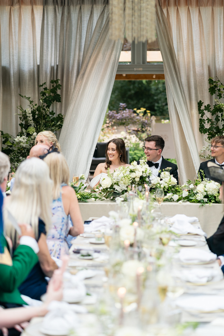 A black and white portrait image of a bride smiling with her bouquet at her marquee wedding in Shropshire planned by Soiree Studio.