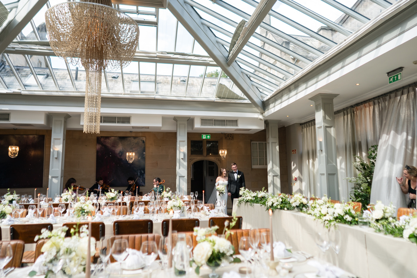 A colourful image of beautiful summer wedding flowers in peach, soft pink and sage for a marquee wedding planned by design-led wedding planner Soiree Studio.