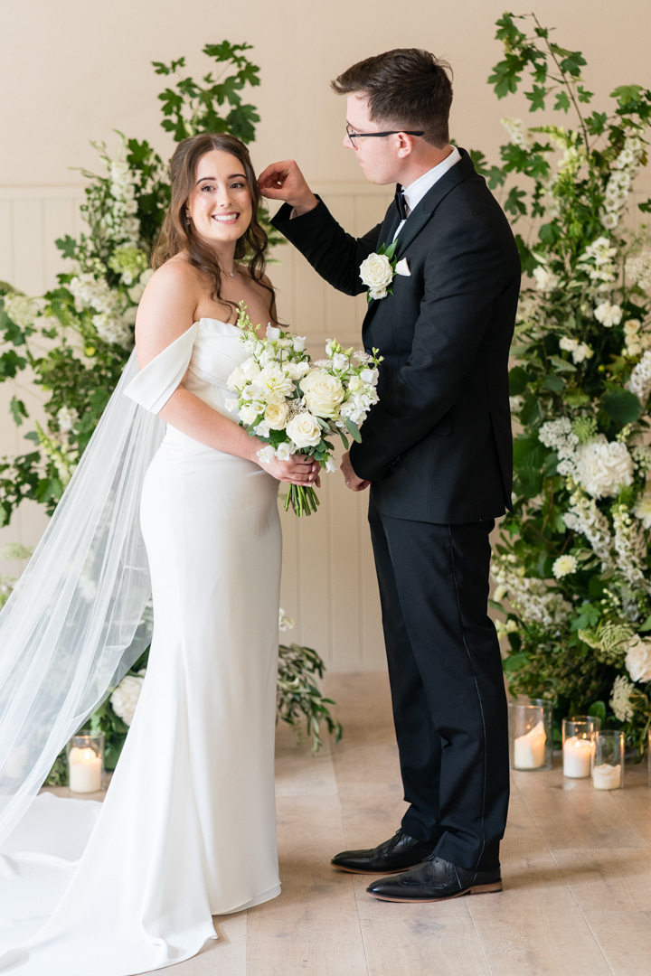 A colour image of a couple at their wedding ceremony at Hampton Manor, wedding planned by Soiree Studio.