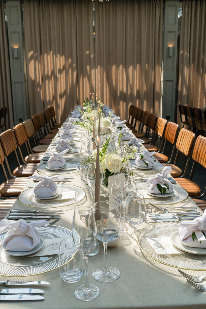 A colour image of a traditional style lambeth cake at a summer marquee wedding with fresh summer flowers in pink and peach in the background, planned by soiree studio in Shropshire.