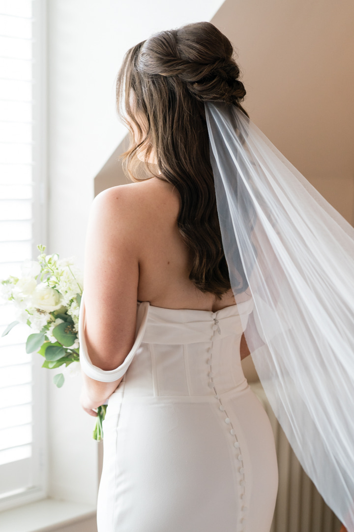 A colour image of a bride and her bridesmaids in butter yellow dresses arriving for a wedding at Nantwich Church in Shropshire.