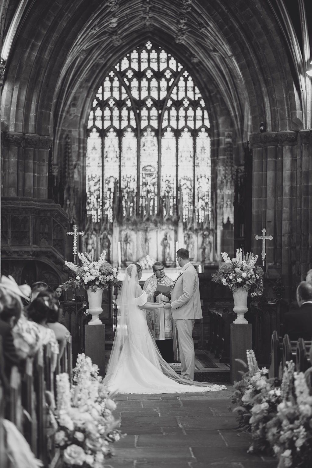A black and white image of a couple at their church wedding ceremony at the altar at Nantwich Church.