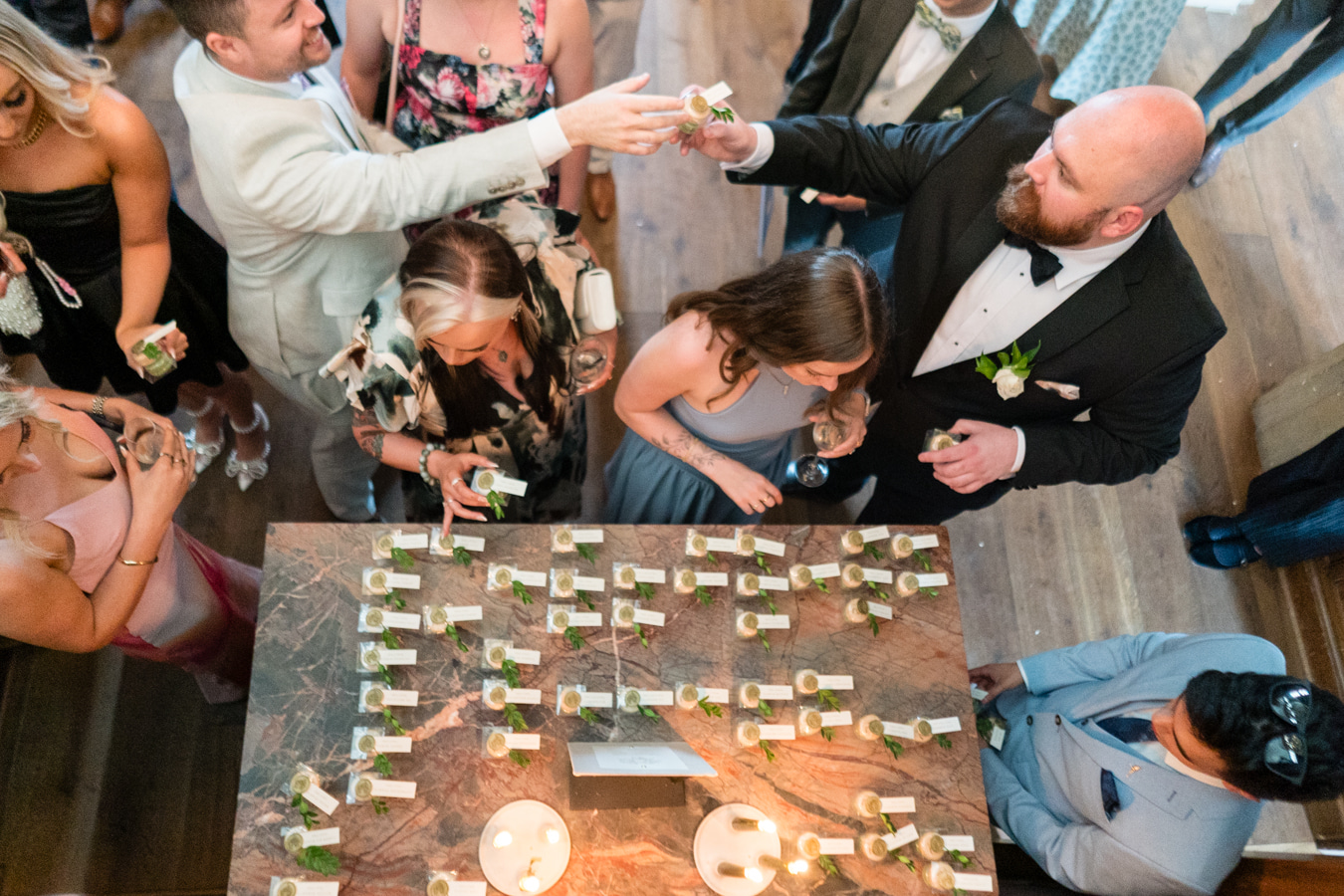 A colour image of wedding guests finding their wedding favours and table plan for a wedding planned by Soiree Studio UK wedding planner.